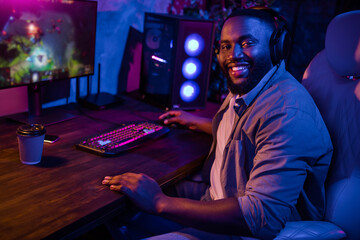 Profile portrait of cheerful handsome person sitting chair beaming smile look camera dark room indoors © deagreez