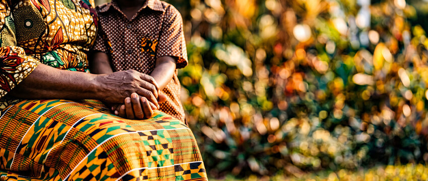 Generations United African Woman and Child Holding Hands in Traditional Kente Cloth Outdoors