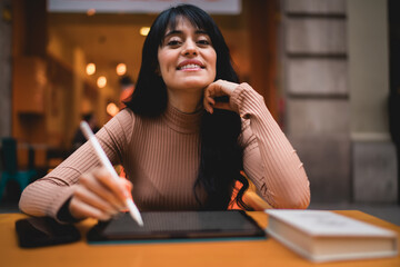Portrait of confident Caucasian female student looking at camera with tablet and stylus pen, managing e-commerce retail store products mobile shopping discount deals and order status © BullRun