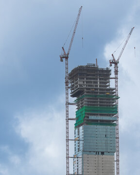 Under Construction with Tower Cranes Against a Cloudy Sky