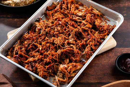 Traditional barbecue pulled pork piece of Bosten butt torn to bits as close-up on a board