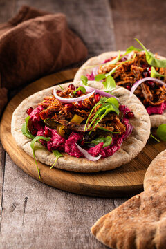 Pulled pork pita with beetroot Hummus and green leaves