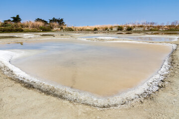 Oeillet d'un marais salant  avec le sel en cours de cristallisation un après-midi ensoleillé. © YVO-Photos