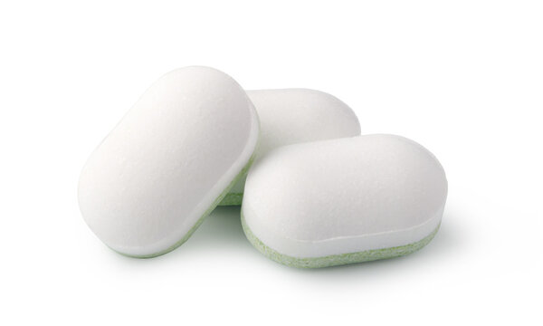 White medicine tablets with green edges isolated on a clean background