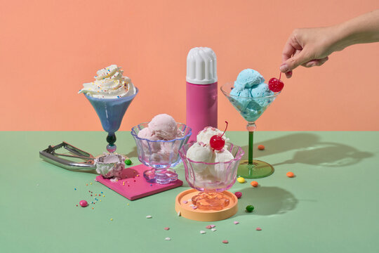 Hand adding cherry to ice cream sundae