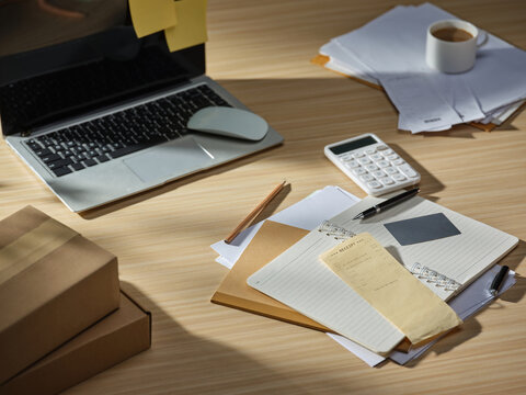 Organized desk with laptop, receipts, calculator, and coffee