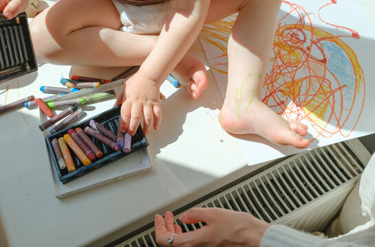 Mother and child drawing together with colorful pastels