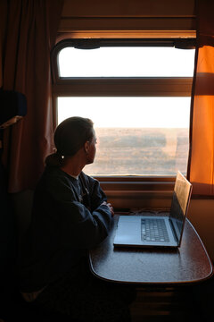 Woman working on laptop while traveling on train