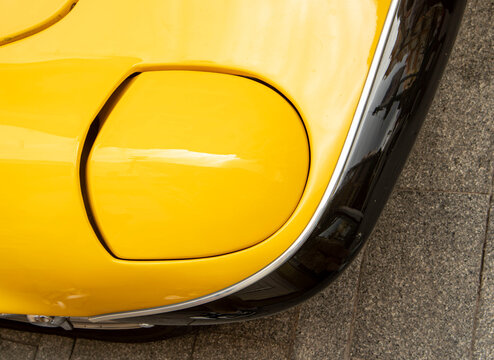 GANDIA, SPAIN - OCTOBER 4, 2026: Front pop-up headlight and bumper detail of a classic yellow 1967 Lotus Elan S3 SE DHC sports car.