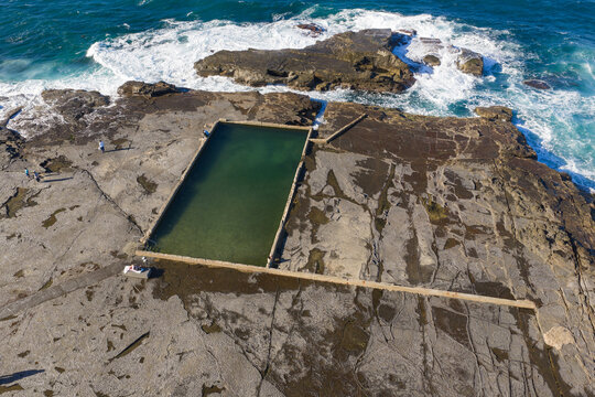 Ocean bath swimming pool on a large rock ledge at low tide