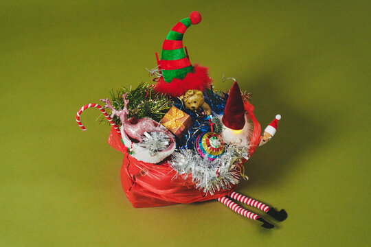 Christmas decorations packed into a red plastic bag with elf legs