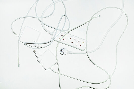 White technology tech wires, cords and charges in office with flashlig