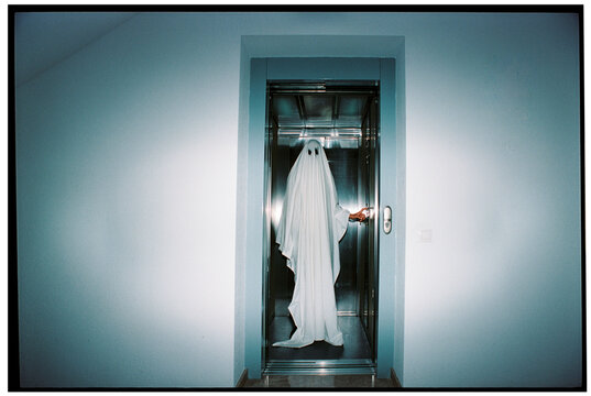 a person in a ghost costume inside an elevator, 35mm film