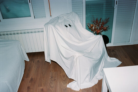 a white sheet forms a ghost over an armchair, 35mm film