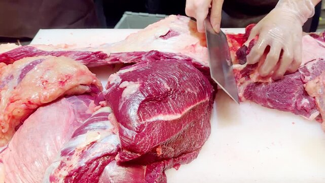 Butcher Hands Cutting Beef into Pieces and Thin Slices &ndash; Meat Shop Preparation