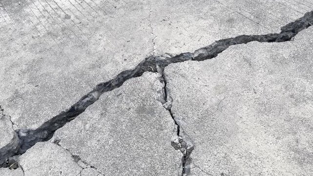 Close up of deep long crack on weathered concrete floor