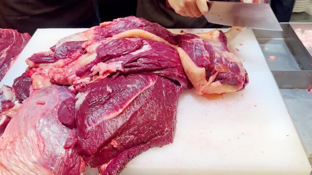 Butcher Hands Cutting Beef into Pieces and Thin Slices &ndash; Meat Shop Preparation