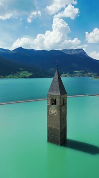 Rising vertical pullback from Curon bell tower at Lake Resia