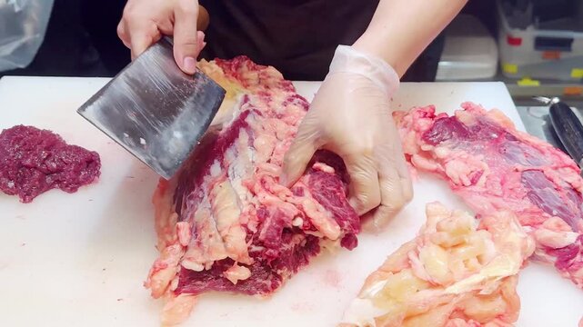 Butcher Hands Cutting Beef into Pieces and Thin Slices &ndash; Meat Shop Preparation