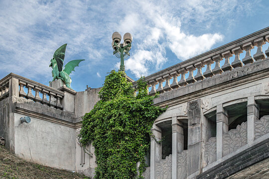 Detail of Dragon Bridge in Ljubljana, Slovenia, featuring a bronze dragon statue and elegant Art Nouveau design spanning the Ljubljanica River, a landmark inaugurated in 1901.