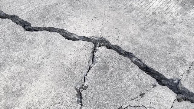 Deep branching crack on damaged concrete road surface