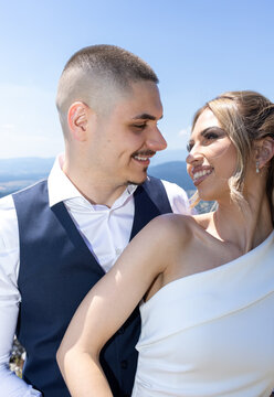 Happy bride and groom smiling at each other during outdoor wedding photoshoot