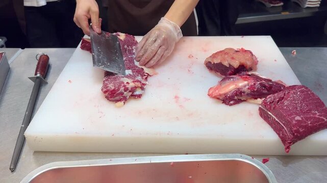 Chef Hands in Gloves Thinly Slicing Premium Beef on White Professional Surface &ndash; Preparing Thin Translucent Meat Layers for Gourmet Dish