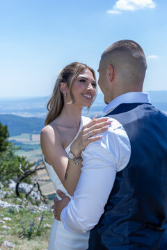 Beautiful bride smiling at groom during romantic outdoor wedding photoshoot