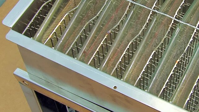 Angled Metal Fin Array Inside an Industrial Frame. Close industrial footage emphasizes repeating metal fins, grids, pipes and structural frame details without claiming a specific function.