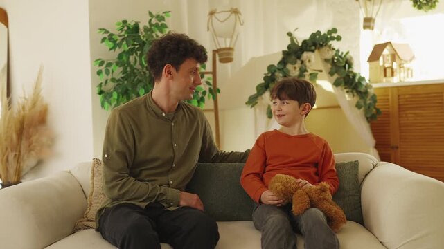 Father and little son talk and smile together during joyful family pastime