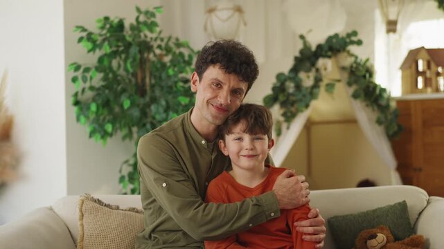 Portrait of cheerful father hugging his little son, warm and happy family bond