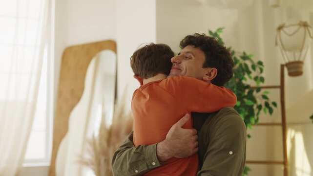Joyful little boy runs and hugs loving dad, sharing warm family relationship