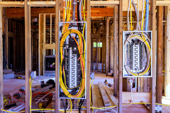 Wiring panels, cables are mounted between timber studs at an indoor construction site