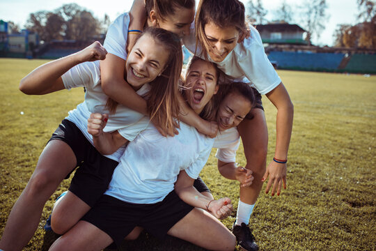 Women's team celebrates with joyful pile on field