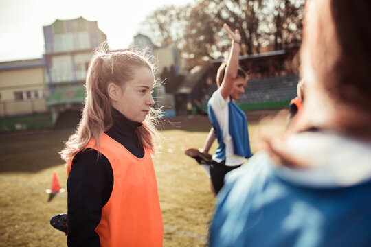 Female athlete in training bib during team warmup on field