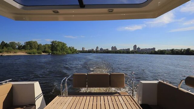 Rear view from luxury motor yacht stern on river with water wake trail in summer