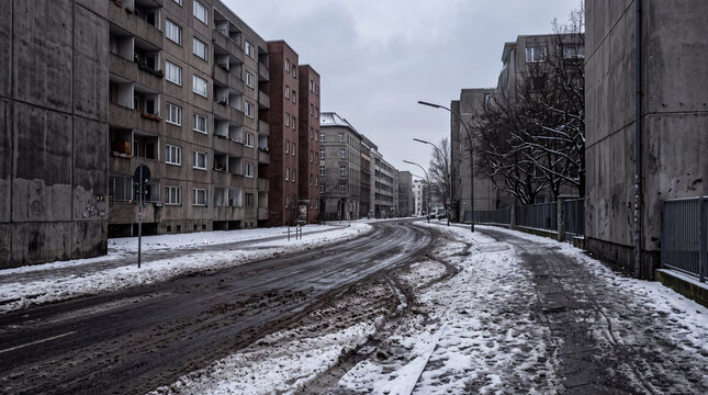 Snow-covered urban road winding between apartment buildings in winter