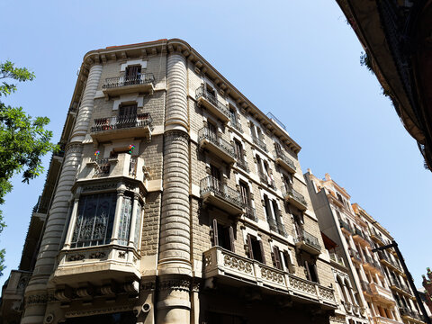 Historic residential building facade with ornate balconies and bay window in Eixample, Barcelona, Spain on a clear sunny day
