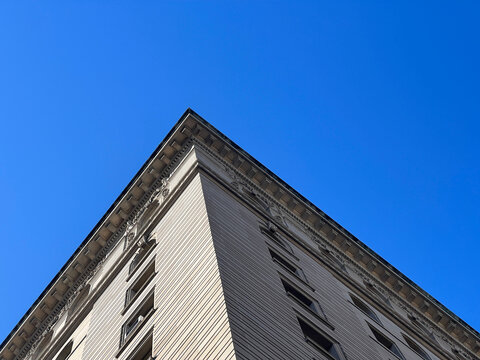 Prewar limestone cornice corner against clear blue sky