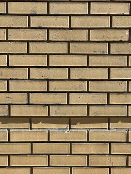 Buff yellow brick wall in an even running bond pattern