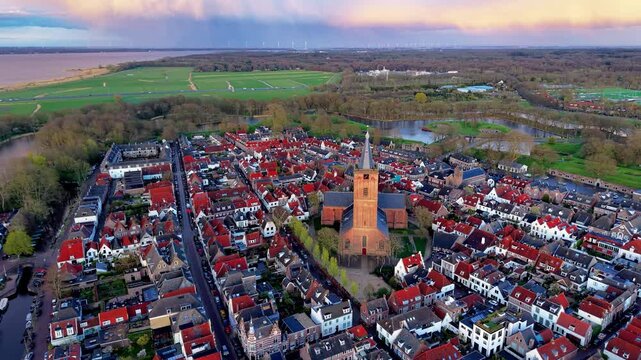 High angle telephoto landscape of historic fortified town Naarden with St Vitus Church red tiled roofs canal moat and Gooimeer lake in North Holland Hanseatic heritage Naarden Netherlands