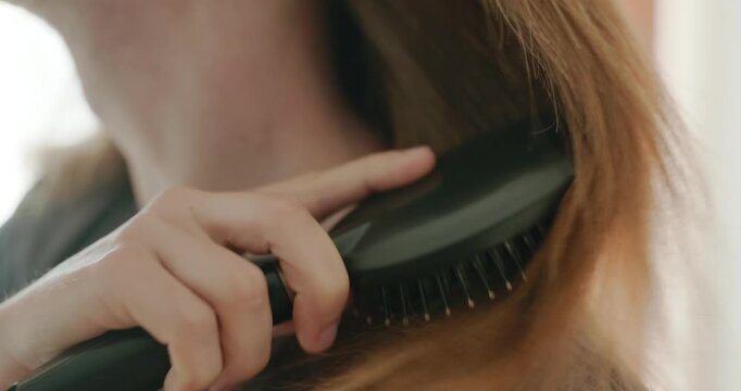 Close-up male hand is combing long hair with a comb. 4K 10-bit