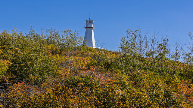 White Lighthouse Tower in Cochin,  Rising Above Colorful Autumn Foliage