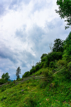 Rustic wooden fence on a lush green hill