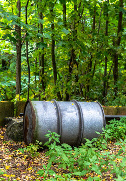 Umweltverschmutzung im Wald, verzinktes altes 200-Liter Metallfass (&Ouml;l- oder Dieselfass) mit umlaufenden Eisenringen zur Verst&auml;rkung, Berlin, Deutschland