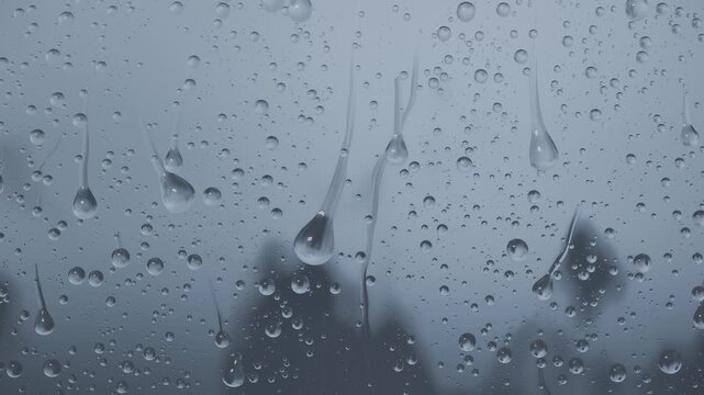 Forming droplets merging into streaks and sliding down window glass rain falling