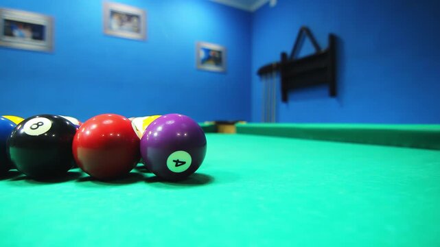 Racked billiard balls green felt close up. Low angle camera pan colorful rack.