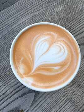 Cup of pumpkin spice latte on wooden table, flat lay