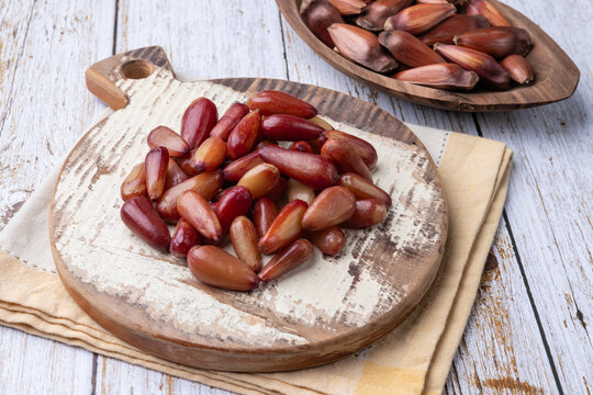 Cooked pinions or araucaria seeds on a board over wooden table