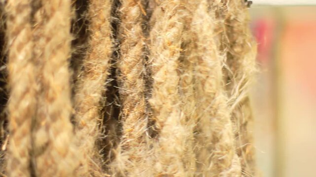 Closeup hanging jute rope. Natural hemp fiber texture rough twisted strands.